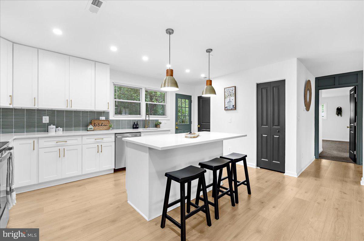 624 Sutton Drive Pasadena, MD 21122 - Photo 8 of 64 a kitchen with stainless steel appliances granite countertop a stove a sink dishwasher a refrigerator and white cabinets with wooden floor
