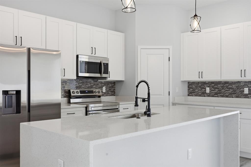 4487 Southwest 152nd Street Ocala, FL 34473 - Photo 13 of 41 a kitchen with stainless steel appliances a stove refrigerator sink and microwave