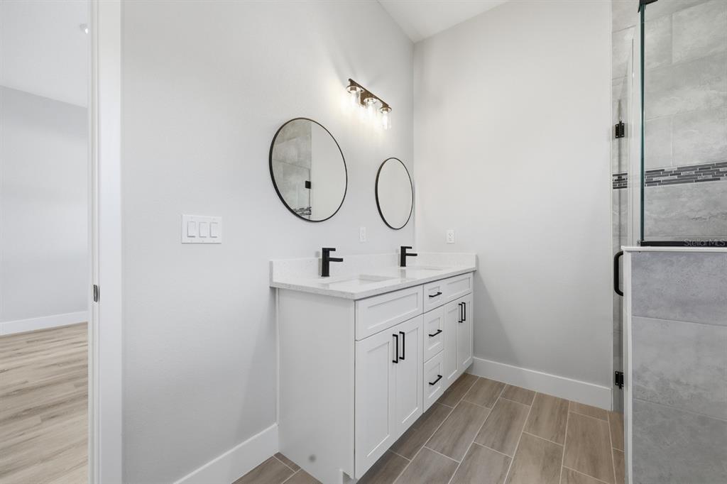 4487 Southwest 152nd Street Ocala, FL 34473 - Photo 22 of 41 a bathroom with a double vanity sink mirror and shower
