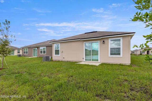 a view of a yard in front of a house with a large tree