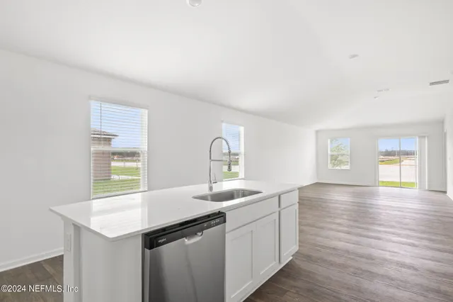a kitchen with a sink cabinets and wooden floor