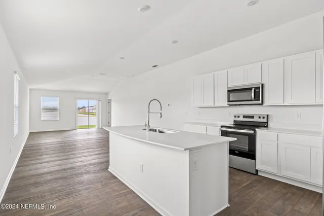 a kitchen with sink a stove and microwave