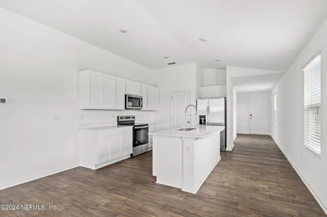 a kitchen with white cabinets and stainless steel appliances