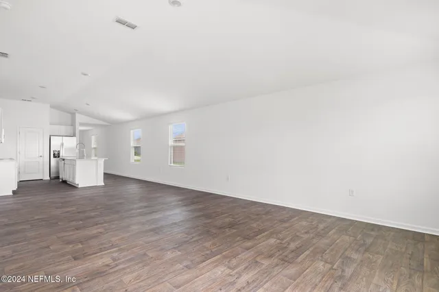 a view of a big room with wooden floor and windows