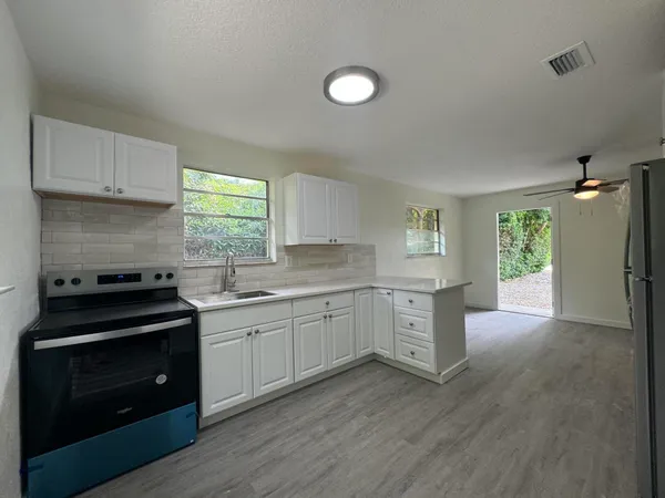 a kitchen with sink cabinets and wooden floor