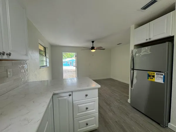 a kitchen with white cabinets and stainless steel appliances