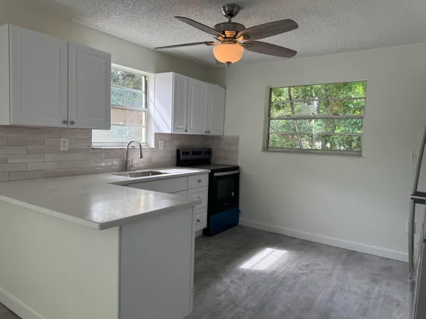 a kitchen with a sink cabinets and window