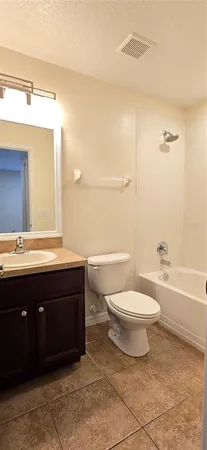 a bathroom with a bathtub shower sink vanity mirror and toilet