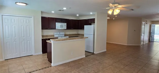 a view of kitchen with stainless steel appliances granite countertop cabinets and refrigerator