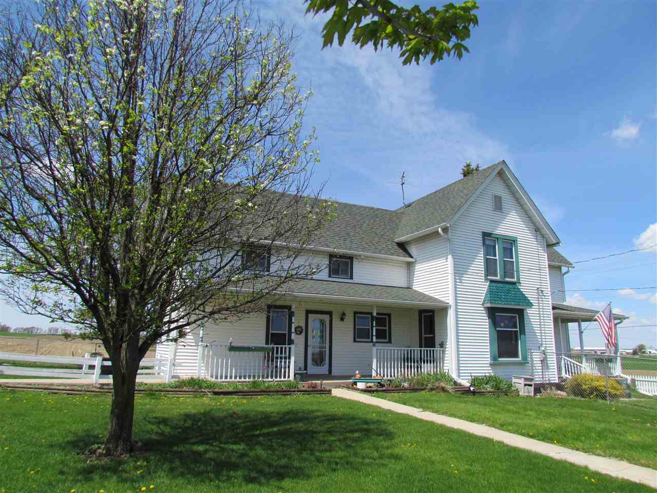 10494 Freeport Road Durand, IL 61024 - Photo 1 of 40 a front view of a house with a garden and trees