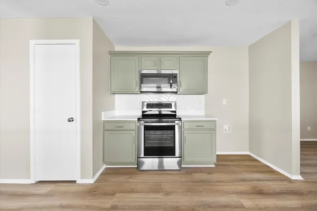 a kitchen with a stove and a white cabinets