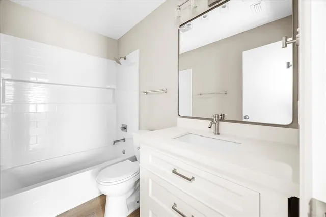 a bathroom with a sink a toilet and a large mirror