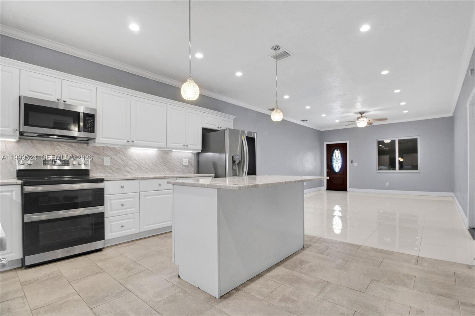 1925 Northwest 49th Street Miami, FL 33142 - Photo 13 of 30 a kitchen with stainless steel appliances kitchen island granite countertop a stove a sink and a microwave