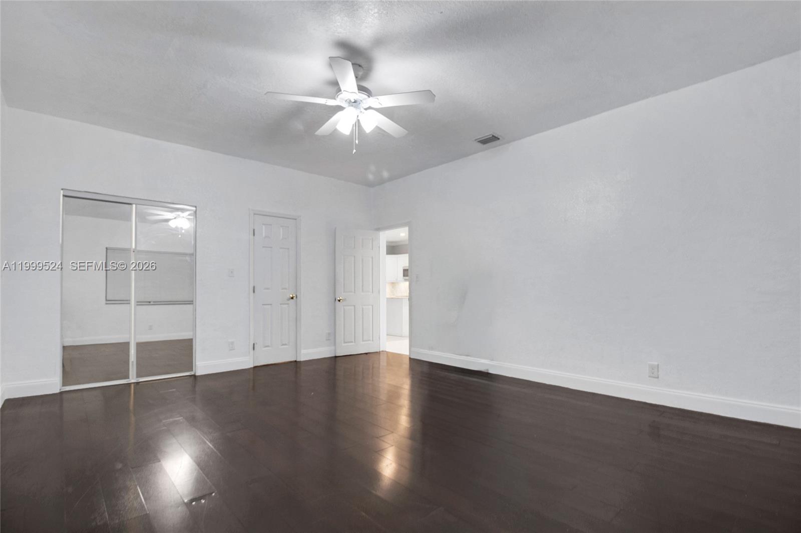 1925 Northwest 49th Street Miami, FL 33142 - Photo 14 of 30 an empty room with wooden floor and fan