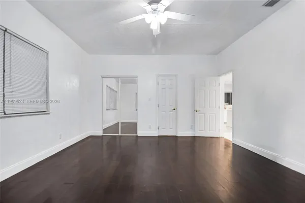 a view of an empty room with chandelier fan