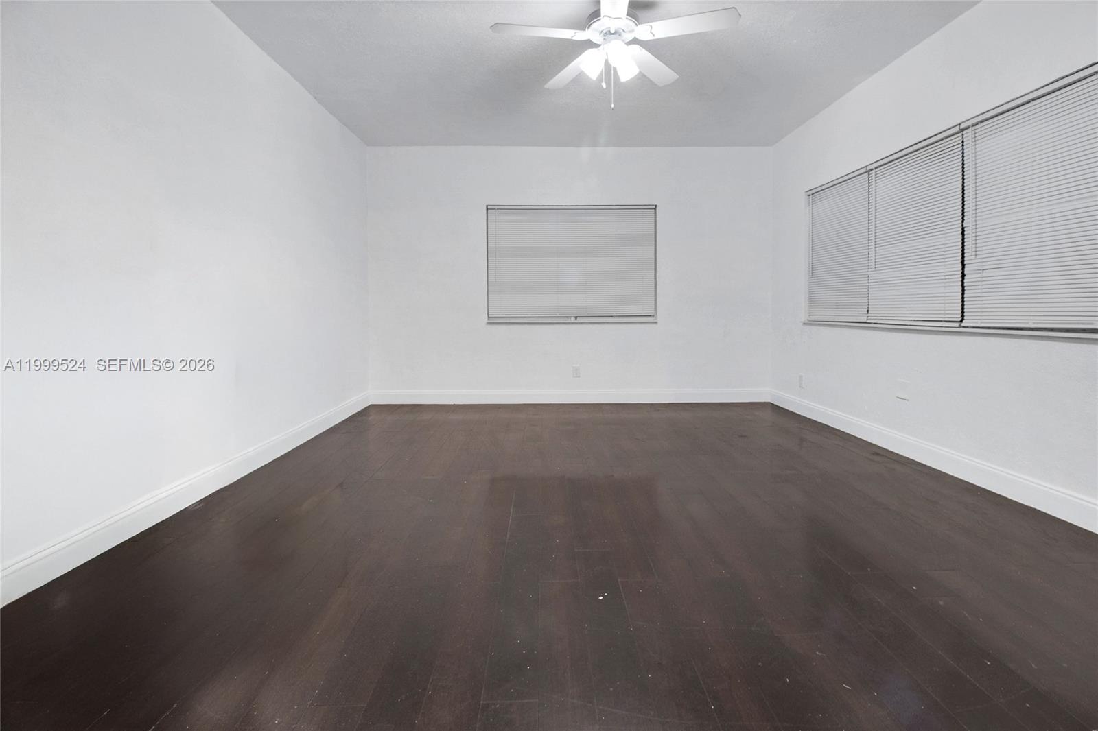 1925 Northwest 49th Street Miami, FL 33142 - Photo 18 of 30 an empty room with wooden floor and fan