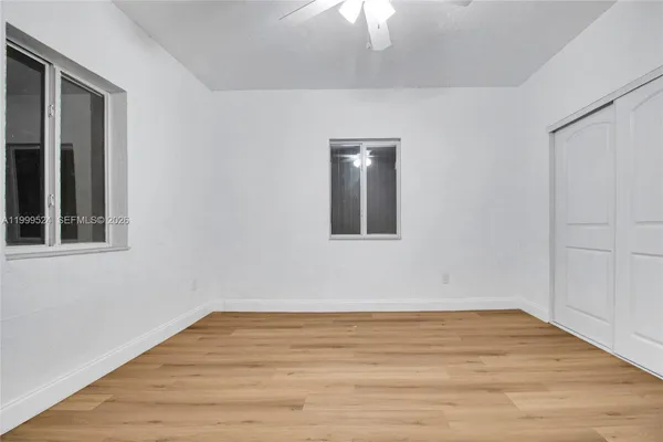 a view of an empty room with wooden floor