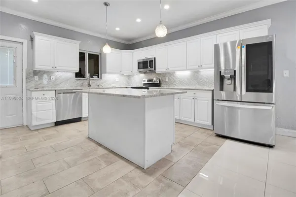 a kitchen with kitchen island a sink stainless steel appliances and cabinets