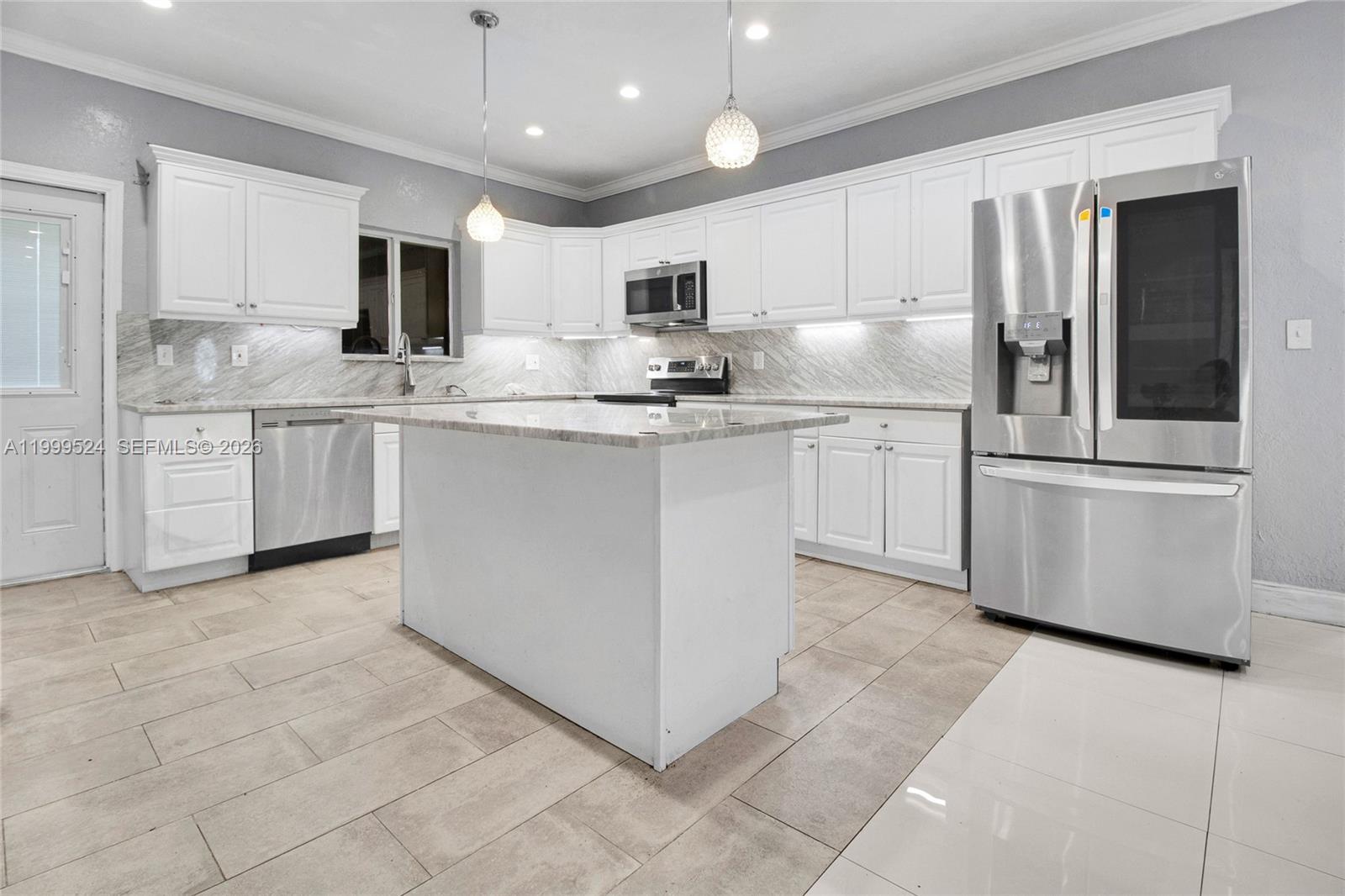 1925 Northwest 49th Street Miami, FL 33142 - Photo 9 of 30 a kitchen with stainless steel appliances granite countertop a refrigerator sink and white cabinets