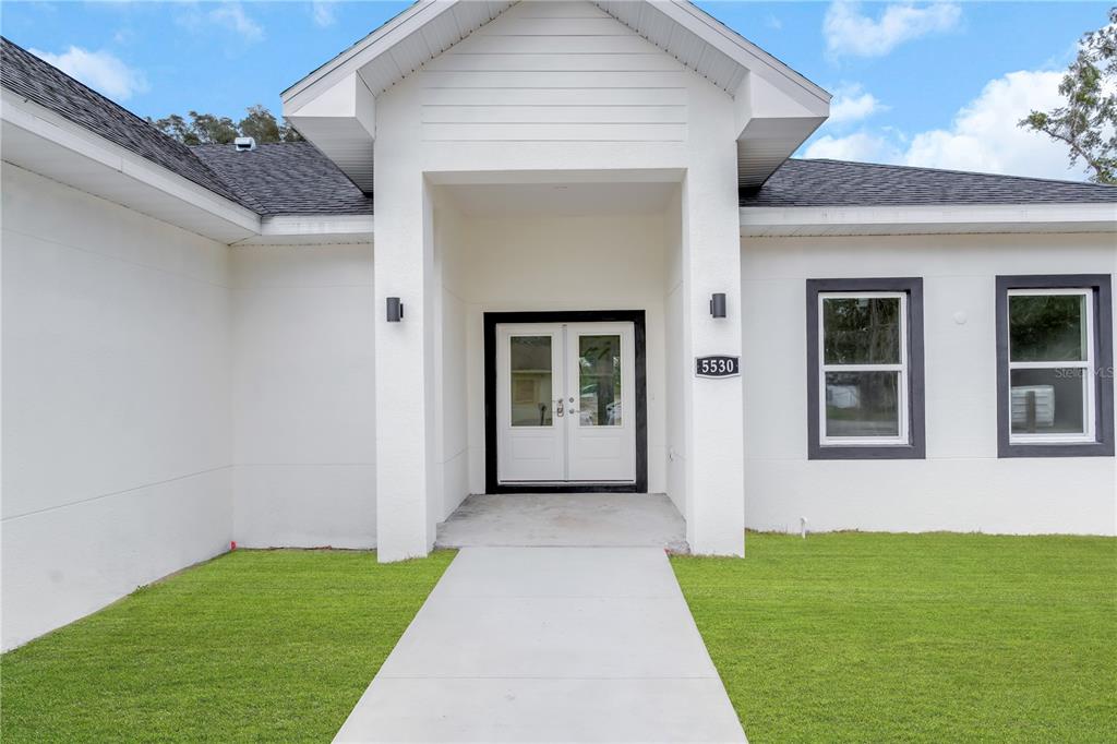 5530 Bell Street Zephyrhills, FL 33542 - Photo 1 of 16 a front view of a house with a yard