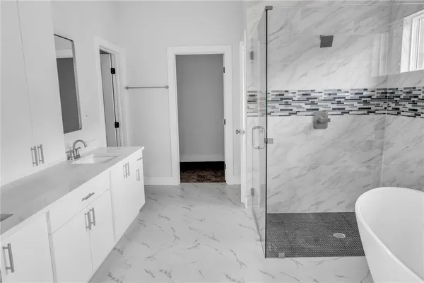 a spacious bathroom with a double vanity sink a mirror and a shower