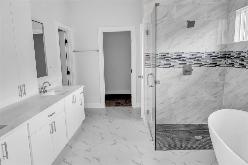 5530 Bell Street Zephyrhills, FL 33542 - Photo 14 of 16 a spacious bathroom with a double vanity sink a mirror and a shower