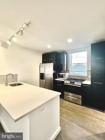 a kitchen with stainless steel appliances kitchen island granite countertop a stove and a refrigerator