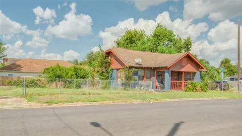 a front view of a house with a yard and potted plants