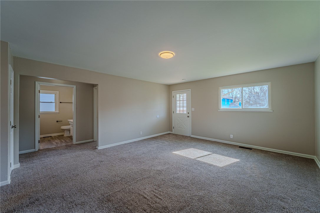 1005 Burt Street Springfield, OH 45505 - Photo 8 of 33 This living room provides a versatile space, featuring comfortable carpet and a well-lit interior.