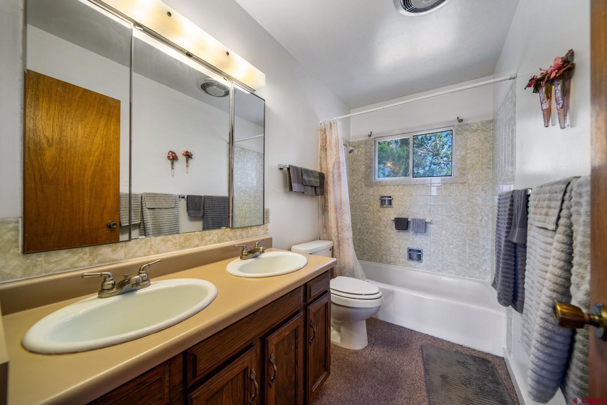 27255 Rd P Dolores, CO 81323 - Photo 16 of 45 a bathroom with a double vanity sink toilet and shower