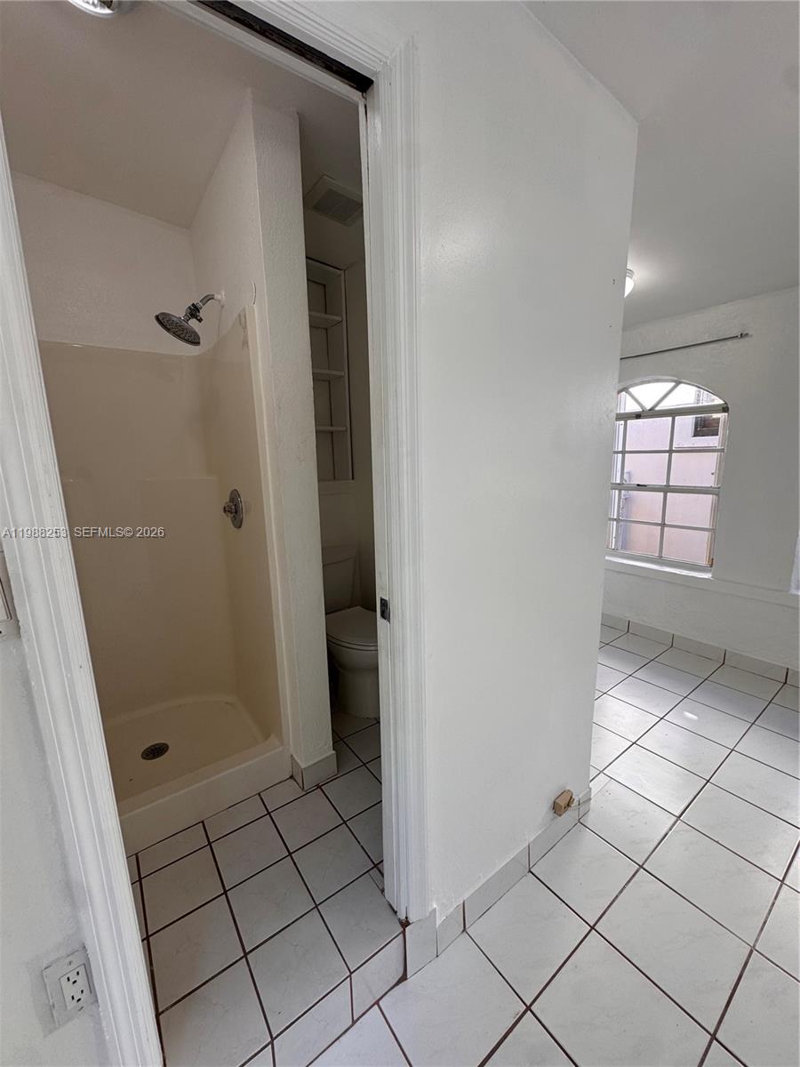 4472 Southwest 9th Lane, Unit 1 Miami, FL 33134 - Photo 8 of 10 a bathroom with a shower and toilet