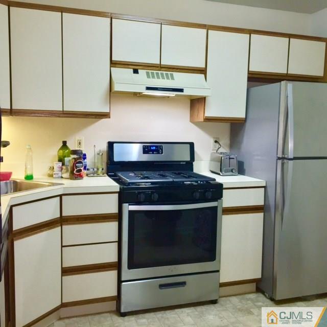 111 Raintree Court, Unit 111 Helmetta, NJ 08828 - Photo 3 of 11 a kitchen with stainless steel appliances granite countertop a stove and a refrigerator
