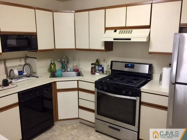 111 Raintree Court, Unit 111 Helmetta, NJ 08828 - Photo 6 of 11 a kitchen with stainless steel appliances white cabinets and a stove top oven
