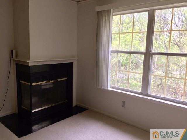 111 Raintree Court, Unit 111 Helmetta, NJ 08828 - Photo 9 of 11 a living room with a fireplace and windows