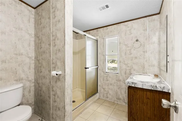 a bathroom with a granite countertop sink a toilet and shower