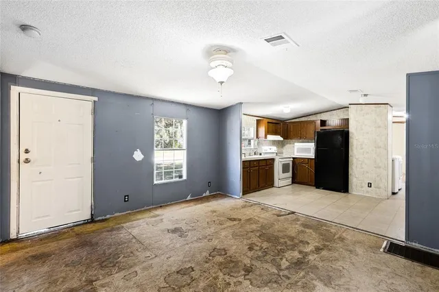 a open kitchen with a refrigerator and window