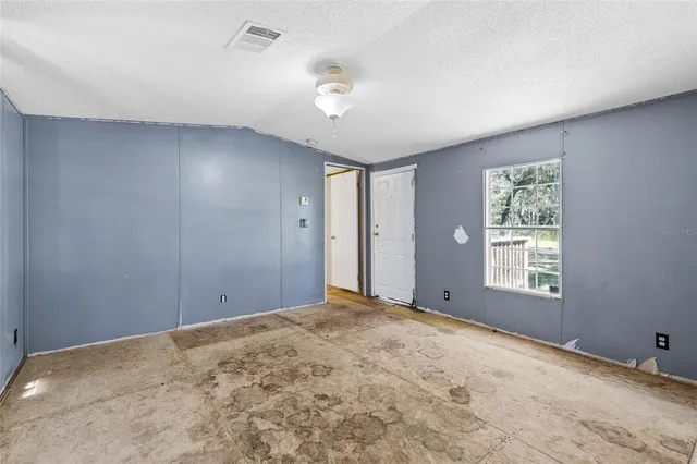 a view of a big room with windows and chandelier fan