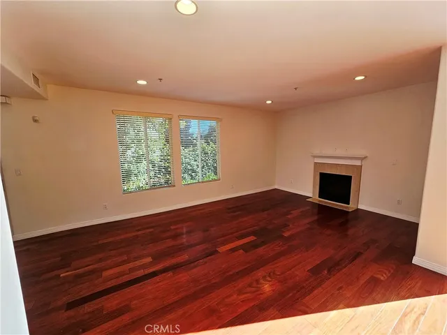 an empty room with wooden floor and a window