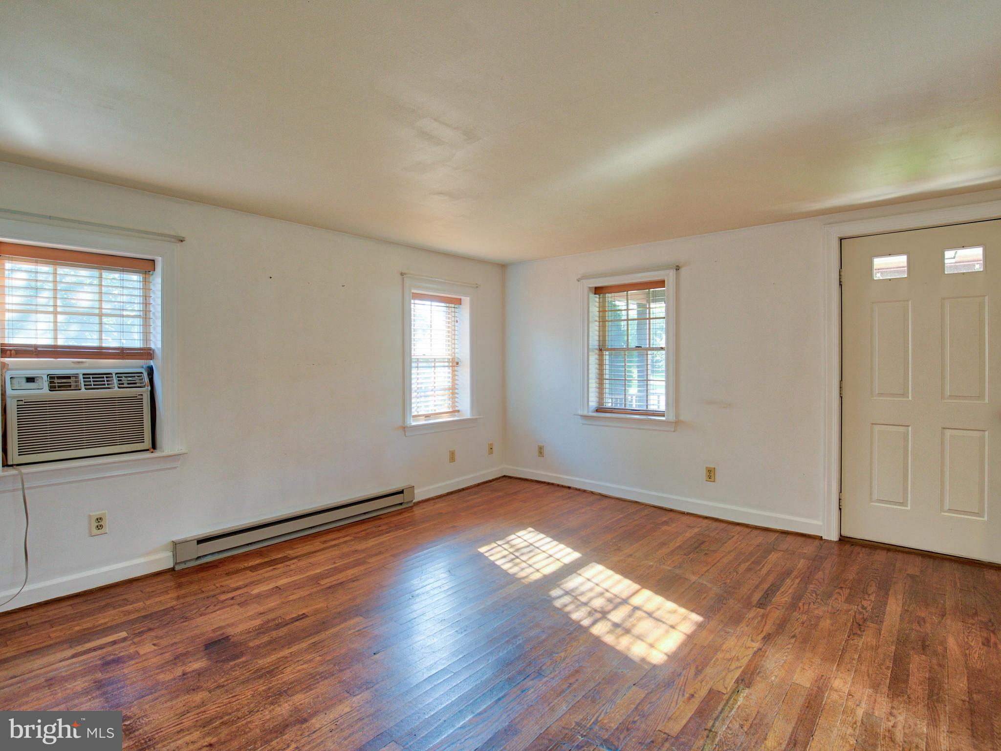 193 Giles Mill Road Bunker Hill, WV 25413 - Photo 13 of 29 an empty room with wooden floor and windows