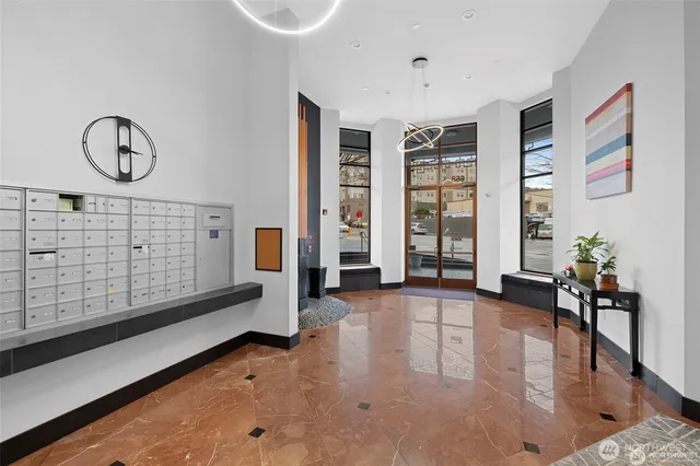 a view of an empty room with window and hardwood floor