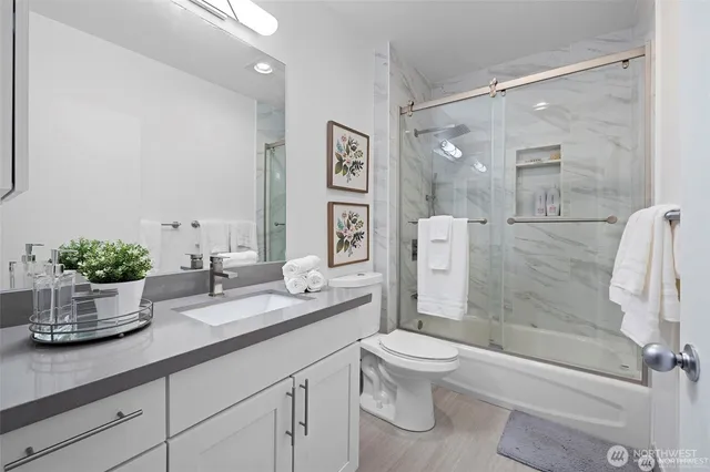 a bathroom with a granite countertop sink a toilet and shower