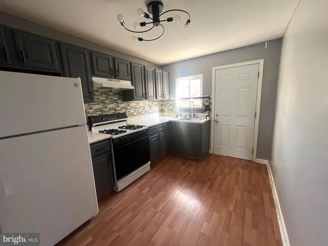 a kitchen with stainless steel appliances granite countertop a stove cabinets and refrigerator