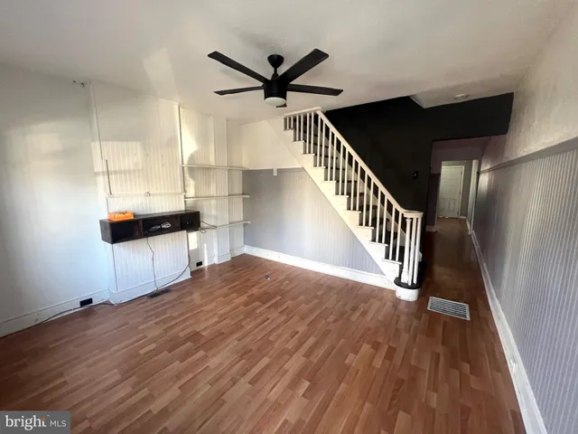 a view of a livingroom with wooden floor and staircase
