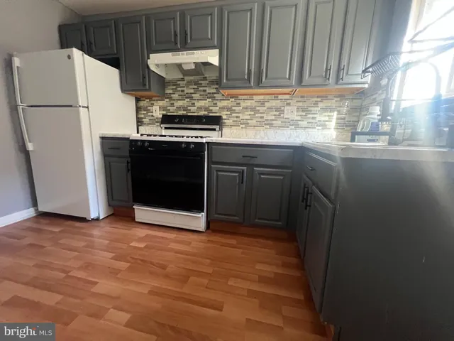 a kitchen with a stove top oven and refrigerator
