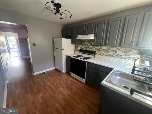 a kitchen with a stove a refrigerator and a sink