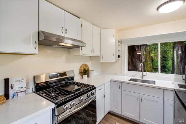 a kitchen with stainless steel appliances a sink stove and cabinets