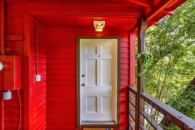 a front view of a house with a red door and wooden floor