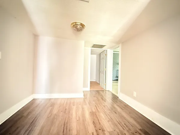a view of an empty room and wooden floor
