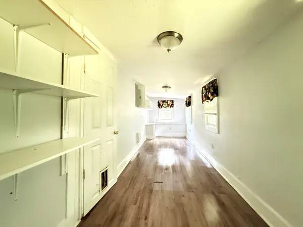 a view of a hallway with wooden floor