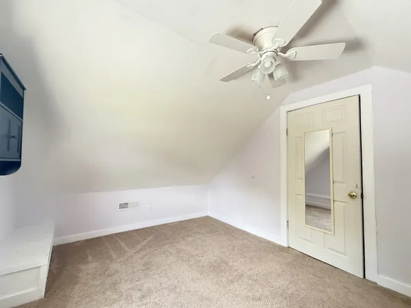 an empty room with a fan and a fan